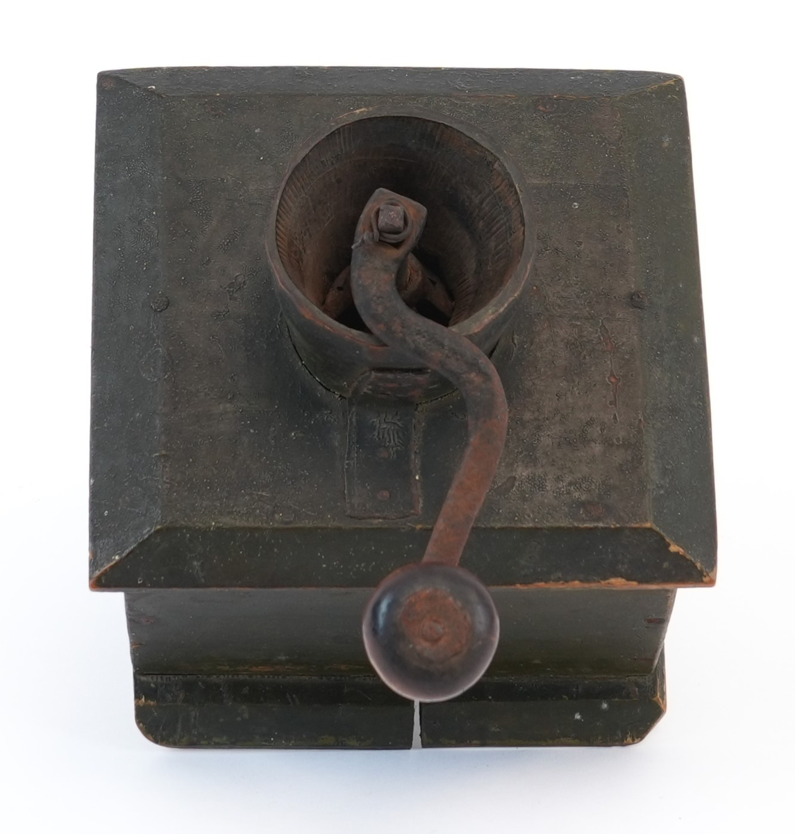 Kaffikvern. Firkanta kasse på sokkelplate, skuff med metallknott. Topplata har avfasa kantar; midt på er ein utgraven kopp til kaffibønnenen og kverna. Sveiva har treknott. Korpus måla mørk grøn utvendig.