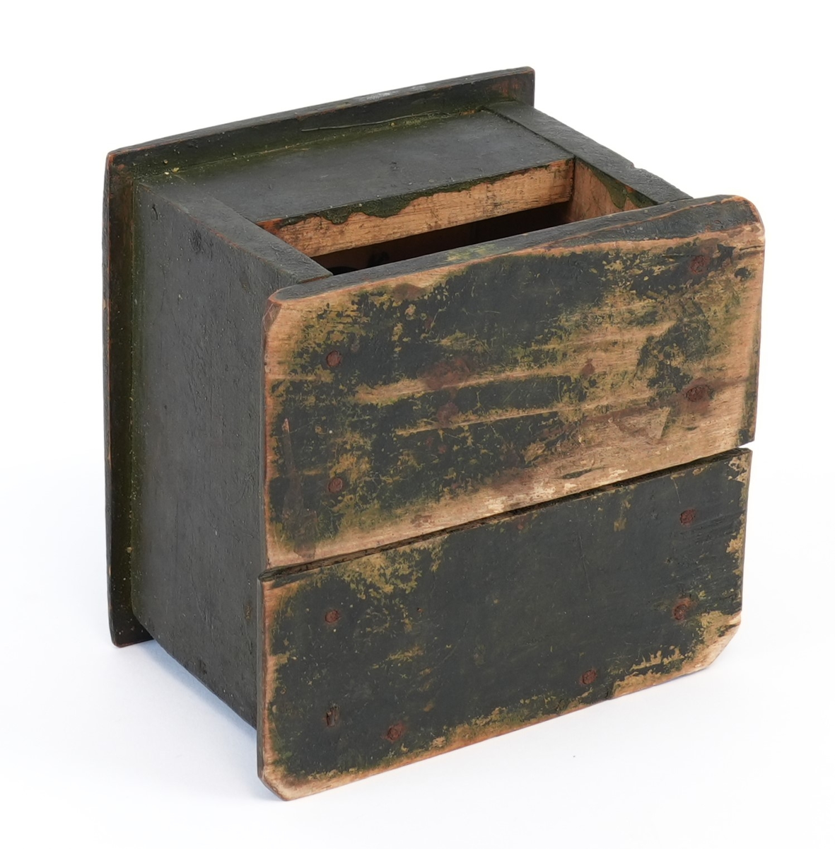 Kaffikvern. Firkanta kasse på sokkelplate, skuff med metallknott. Topplata har avfasa kantar; midt på er ein utgraven kopp til kaffibønnenen og kverna. Sveiva har treknott. Korpus måla mørk grøn utvendig.