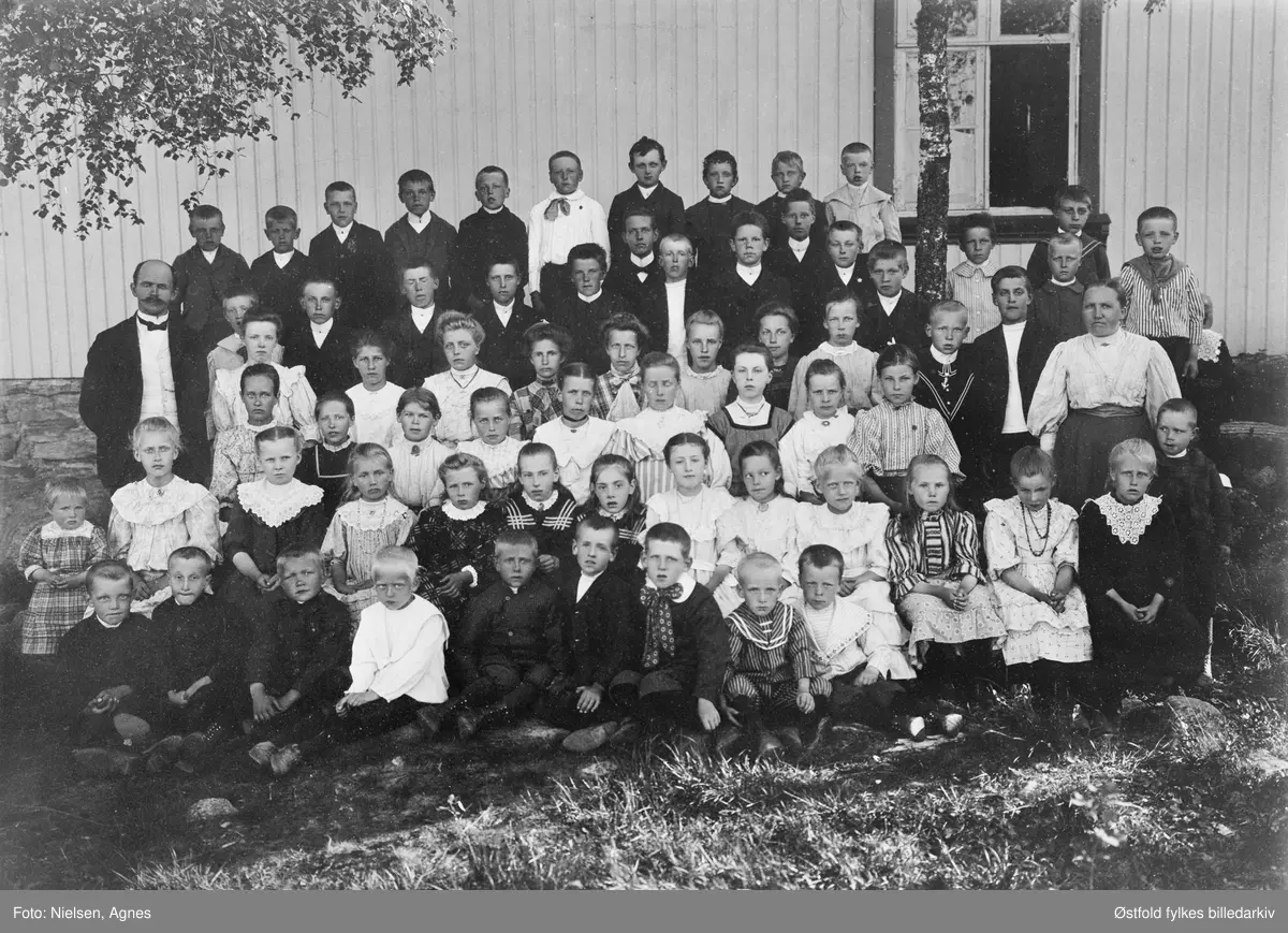 Gruppebilde fra Kokkim skole i Varteig ca. 1910, med 68 elever og lærer Harald Hansen med frue Thea Hansen. Bildet er tatt utenfor skolen. Navneliste%