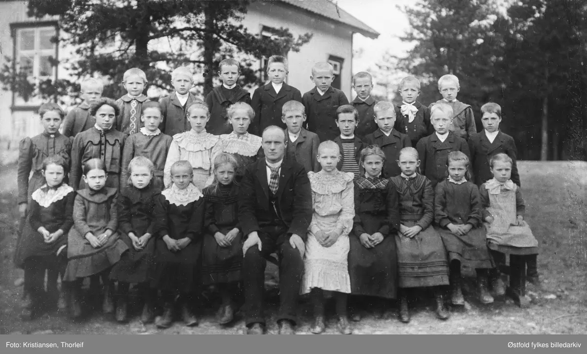 Strømnes skole  i Varteig 1906 med sin lærer Peder Gresset. Han var fra Nordmøre. Bildet er tatt utenfor Strømnes skole. Navneliste med plassering se fotokort%