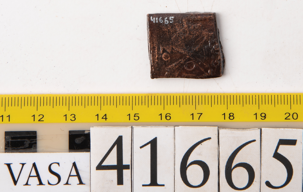 Â½- öre

Fyrkantigt mynt.

Åtsidan: mitt på myntet en vasakärve, svagt synlig.

Till vänster om kärvens bas versalen G. Ovanför kärven versalen A, delvis synlig.

Ocentrerad prägling. Ram delvis synlig.

Frånsidan: två korsade pilar under en krona, svagt synliga.

Till vänster om pilarna valören Â½, till höger versalen Ö, svagt synliga.

Det tvåsiffriga präglingsåret - längst ner på myntet - är 26 (1626).

Ocentrerad prägling. Ram delvis synlig.

Nuvarande skick: bägge sidor slitna.

Vikt: 12,5 gram.



Text in English: Square-shaped coin. Denomination: Â½ - öre.

The obverse side has a Vasa sheaf in the centre, faintly  visible. The initials G A appear in capital letters.  G placed to the left and A above the sheaf. A is only partly visible.

The coin stamp is off-centre. The frame is partly visible.

The reverse side has two crossed arrows beneath a crown, faintly visible. On the left hand side is the fraction Â½, and on the right the initial Ö, faintly visible.

The two digit year of coinage, 26 (1626), is placed beneath the arrows.

The coin stamp is off-centre. The frame is partly visible.



Present condition: both sides are worn.

Weight: 12,5 gram.