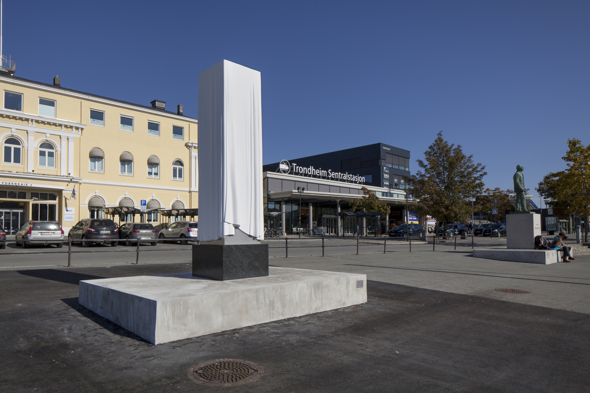 Et sirlig drapert hvitt klede over en ennå ikke avduket skulptur.