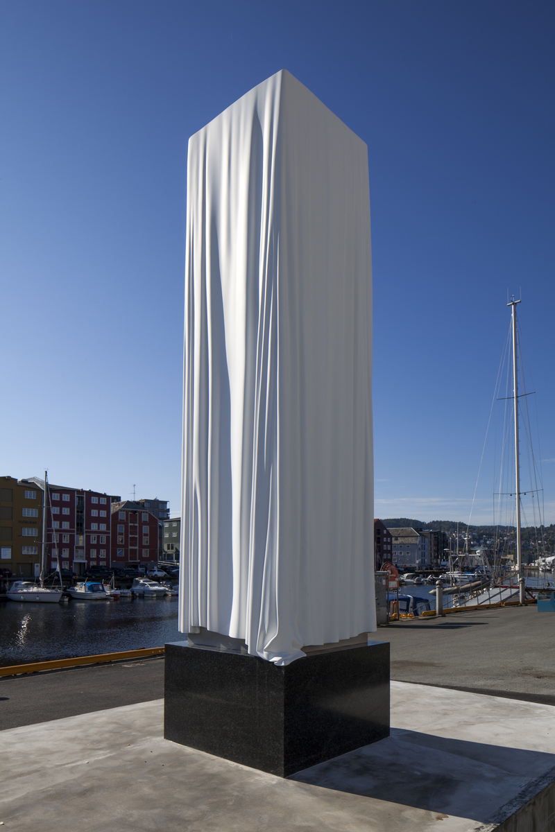 Et sirlig drapert hvitt klede over en ennå ikke avduket skulptur.