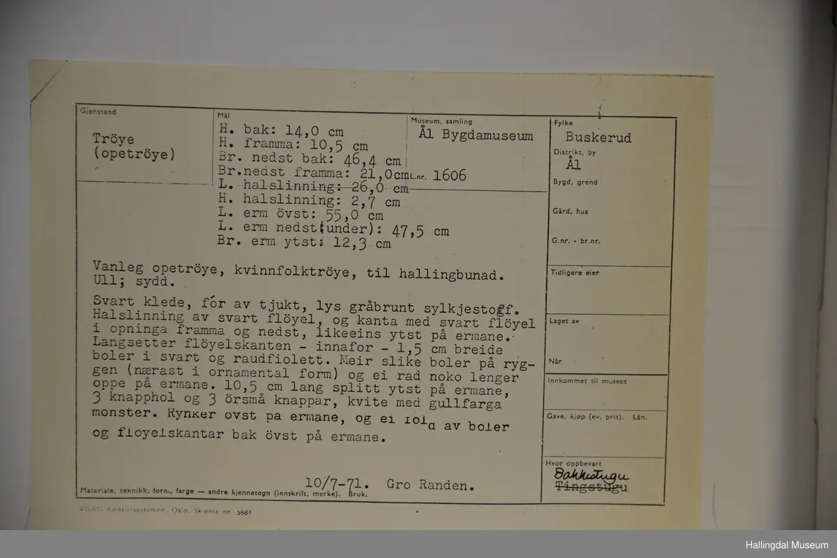 Opetrøye i svart klede, for av tjukt, gråbrunt sylkjestoff. Halslinning i svart fløyel og kanta med svart fløyel i opninga framma og nedst, likeins ytst på ermane. Innafor fløyelskanten boler i svart og raudfiolett. Meir slike boler på ryggen og på ermane. Splitt ytst på ermane, 3 knapphol og 3 små knappar, kvite med gullfarga mønster. Rynker øvst på ermane og ei fold av boler og fløyelskantar bak øvst på ermane.