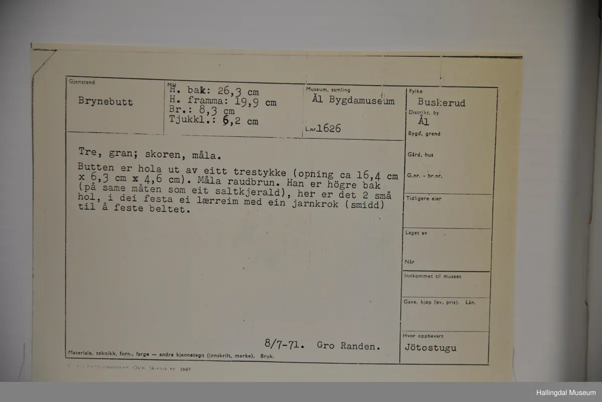 Butten er hola ut av eitt trerstykke. Han er høgare bak. Her er det to små hol, i dei festa ei lærreim med ein jarnkrok til å feste i beltet.
