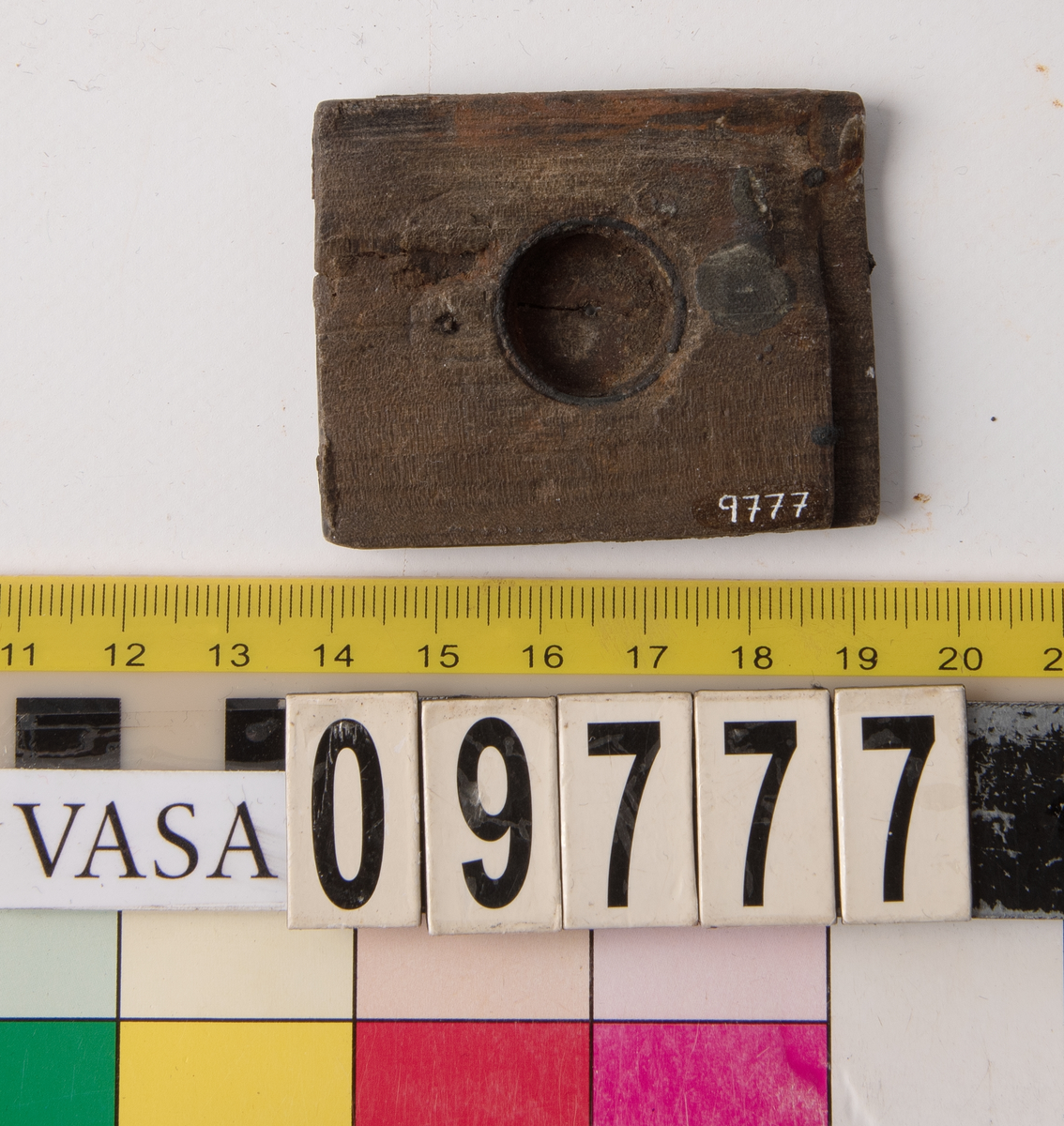 Del av ett solur. 
Träplatta med runt urtag.  Metallring längs kanten i urtaget. Fals i ena änden.