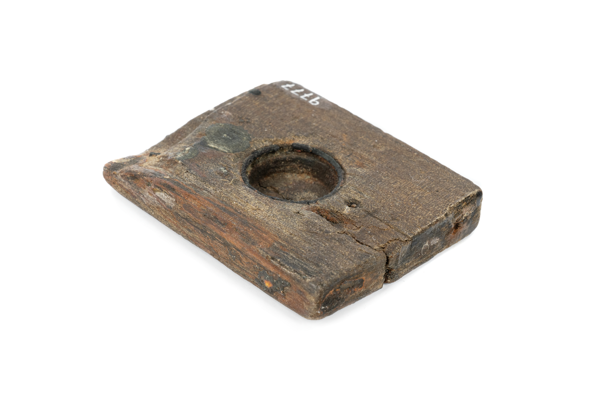 Del av ett solur. 
Träplatta med runt urtag.  Metallring längs kanten i urtaget. Fals i ena änden.