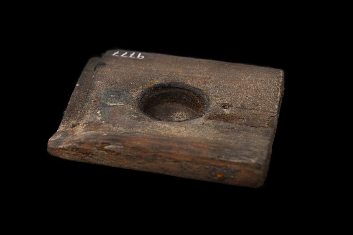 Del av ett solur. 
Träplatta med runt urtag.  Metallring längs kanten i urtaget. Fals i ena änden.