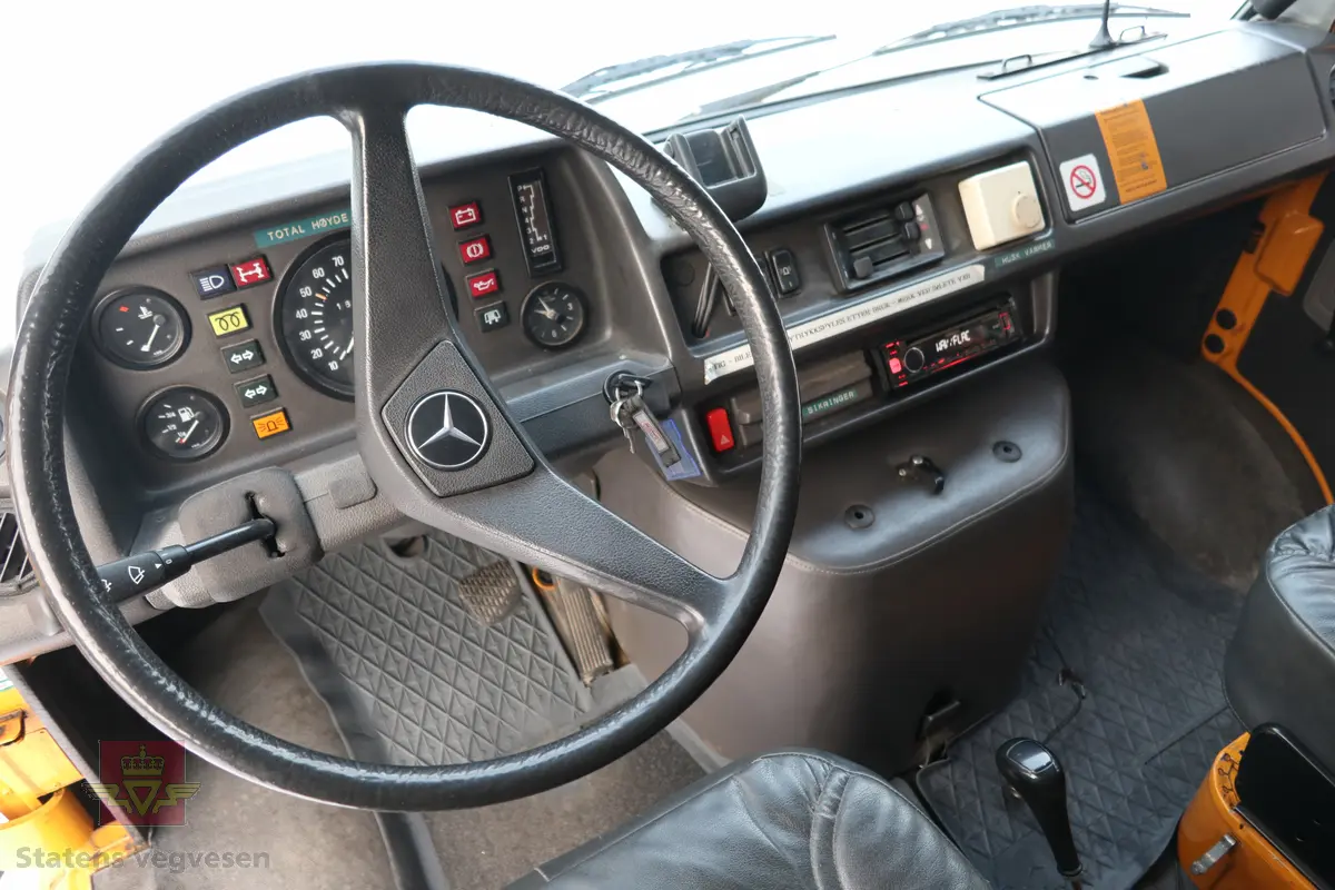 Mercedes-Benz 310D. Bilen er 4-dørs, sølv farget med vegvesen profilering. Grått interiør. Bilen har en vannavkjølt, dieseldrevet 5-sylindret motor av typen OM 602 (602.9). Motoren har et sylindervolum på 2874 kubikkcentimeter. Motorytelse/effekt er 98 hk/72 kW og maks turtall er 3800. Automat girkasse med spak i gulvet. Antall sitteplasser er 8. Dekk foran og bak skal standard være 215R X 14C. Kilometerstand er 160856 km.