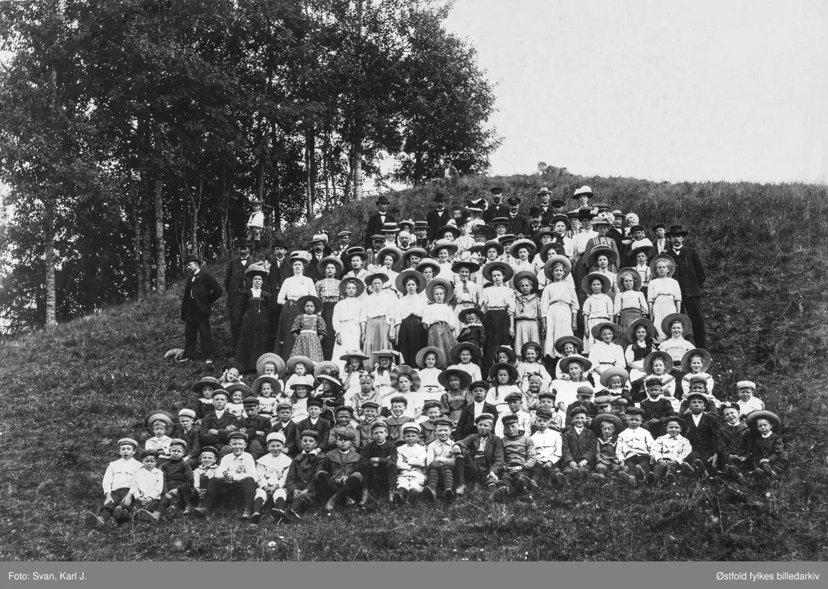 Alvim Søndagsskole fra Tune på tur med DS Krabben, antakelig  Skjørshammer i Eidsberg 1909.
Navneliste: 
1.  rekke fra venstre: 
4. Sigurd Olsen (Isebakke)
5. Arnt Halvorsen
6. Aleksander Henriksen
7. Rolf Olsen
8. Hans Jensen
9. Mathisen
10. Holger Henriksen
11. Bernt Halvorsen
12. Thorstein Jelsnes
13. Jens Johansen
16. Gerog Hansen
18. Olaf Olsen (Isebakke)

2. rekke: 
1. Sverre Larsen
2. WIlliam Mikalsen
4. Karlstad
12. Algot ALgren
13. Karl Olsen (Isebakke)
16. Gunnar Ansersen (Brevik)
18. Hans Kristiansen

3. rekke: 
7. Hansine Hansen
8. Grønberg
9. Ottesen
11. Harda Johnsen
13. Anie Markusen
14. Inga Markusen

4. rekke: 
10 Rebekka Pettersen
11. Marie Andersen
14. Jenny Reiersen

5. rekke (stående): 
5. Marie Klausen
7. Urholmen
8. Andreassen
9. Petra Olsen
10. Ragnhild Olsen, Brevik
11. Astrid Klausen

De som står bakenfor rekke 5 er vanskelig å plassere i noen bestemt rekkefølge, men det er tatt med navn på de man kjenner igjen: 
Anton M. Mikalsen med hunde Beauty, Anette Eilertsen, Motzfeldt, Laura Jensen, Astrid Olsen, Sara Pettersen, Olga Motzfeldt, Martha Jensen, Peder Thoresen, Otto Jensen, Johan Kristiansen, Alfred Olsen Isebakke, Hansen-Horjen, Petter Motzfeldt, Johan Hansen (Tunebakken), kaptein Johan Johannesen på Krabben, Jørgen Olsen, Vetterlin med flere, Edvard Mellebye.
Dampbåten  DS Krabben gikk i rute langs Glomma fra Glengshølen i Sarpsborg til Lindhol i Eidsberg med mange stoppesteder underveis på begge sider av Glomma i perioden 1869 til 1947.
