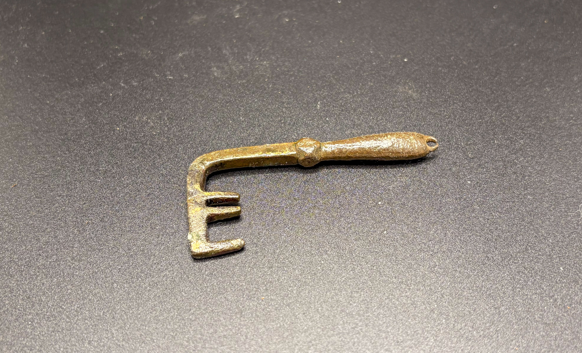 Tre-kloigt ax vinkelrätt mot skaftet som har fyrkantigt tvärsnitt handtaget spolformat och avslutat med en ögla
av brons. Funnen vid gerete i follingbo, år 1866.