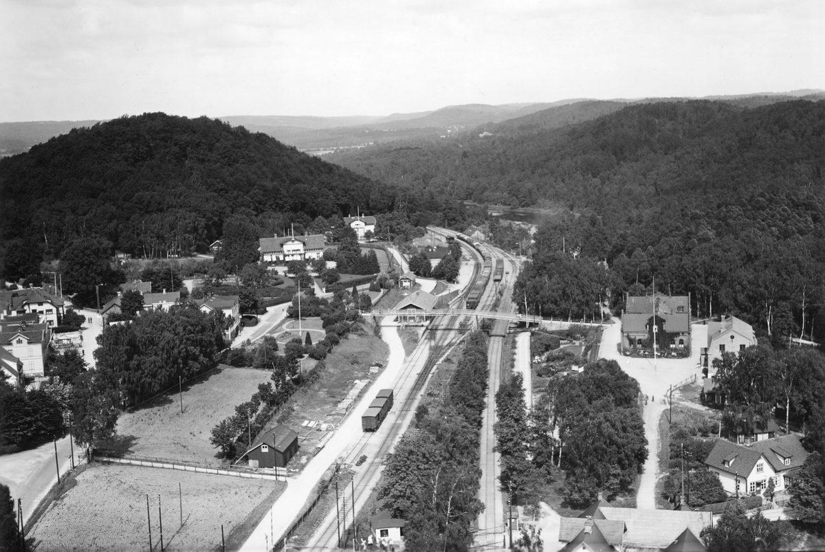 Flygfoto över Oskarström från 1935 med järnvägen i bildens mitt och bebyggelsen på ömse sidor. En gångbro leder över järnvägen. Orten ligger utmed Halmstad-Nässjö järnväg, där linjen mellan Halmstad och Värnamo invigdes 1877. (Se även bildnr F9352.)