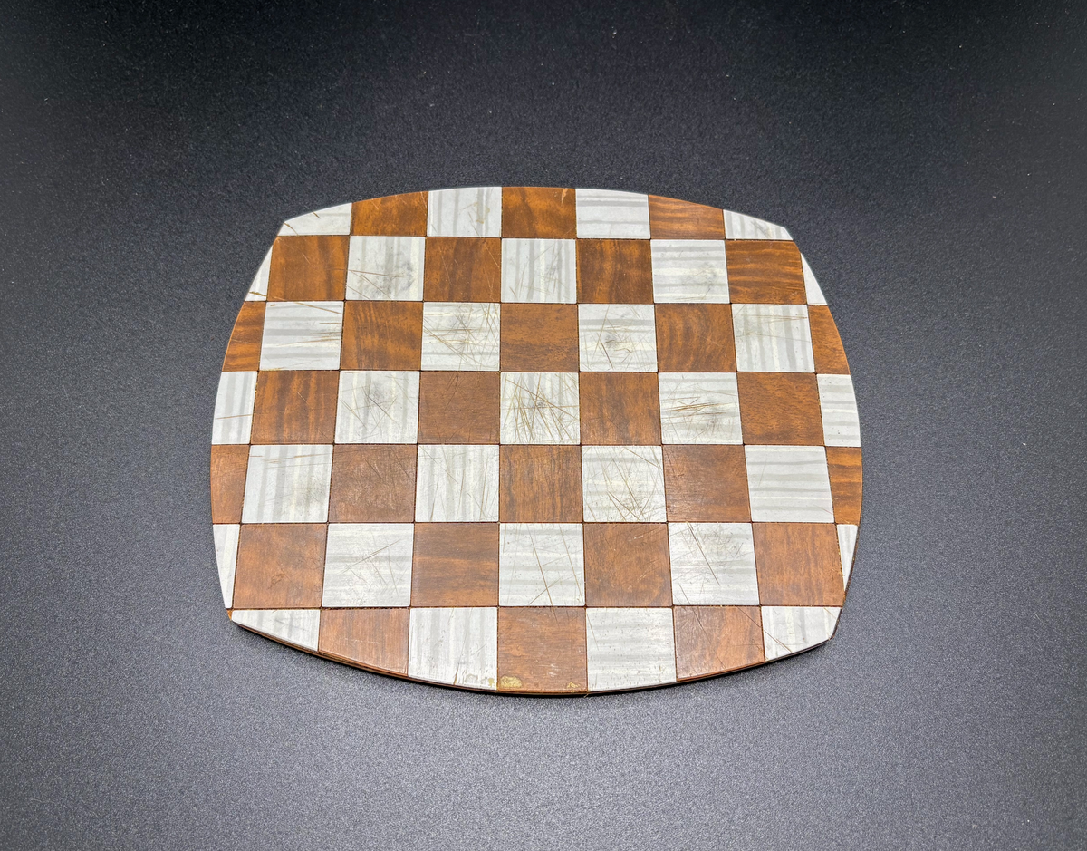 Rektangulärt, med något svängda kanter. Av masonit med yta av perstorpsplatta, grå och brun lagd i rutmönster, fyra runda "tassar" av masonit under.  Har använts i museets (fornvännernas) uthyrningslägenheter, när fastigheterna såldes tillvaratogs en del husgeråd och möbler och införlivades med samlingarna
nyreg data 001115 li

bilden föreställer gfc13517_1 och gfc13517_2.