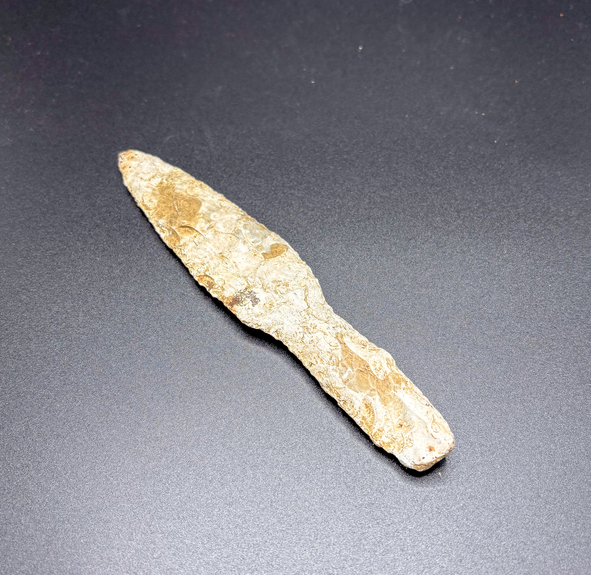 Av gråvit flinta  plant blad med finhuggna kanter handtaget har spetsovalt tvärsnitt  enligt orginalkatalogen funnen i klinteåker
l. 179 mm. Största br. 32 mm. Från klinte i follingbo. Funnen i klinteåker.