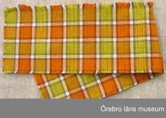 Sju vävprover av randigt eller rutigt överdragstyg i tuskaft. Varp av cottolin i färgerna orange, gul, brun, blekt. Prov 2 har färgerna blå, blågrön och brun, Inslag av oblekt towgarn i randiga prover  och i rutiga prover cottolin av samma färger som varpen. Proverna har skillnader i färgnyanser och troligen vävda vid olika tidpunkter.1: mått 100x155mm. Rutigt . Fastnitat på kartong tillsammans med prov 2. Baksidan har vävuppgifter. Bild A.2: mått 135x110. Rutigt i blå färger. Fastnitat på kartong tillsammans med prov 1, baksida med vävuppgifter. Bild A.3: mått 170x150mm. Rutigt och randigt parti. Bortklippt del. Samhör med väv beställning nr 1167 daterad 8/2 1964.4 och 7: mått 155x620mm resp 265x140mm. Rutiga. Nyansskillnad. Bild B.5-6: mått 980x155 resp 990x100mm. Randiga. Nyansskillnad.  Bild C visar prov 5.Se även ÖLS120084.