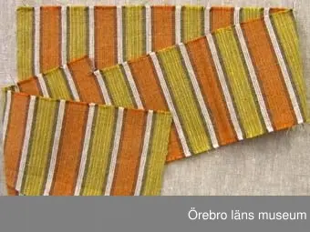 Sju vävprover av randigt eller rutigt överdragstyg i tuskaft. Varp av cottolin i färgerna orange, gul, brun, blekt. Prov 2 har färgerna blå, blågrön och brun, Inslag av oblekt towgarn i randiga prover  och i rutiga prover cottolin av samma färger som varpen. Proverna har skillnader i färgnyanser och troligen vävda vid olika tidpunkter.1: mått 100x155mm. Rutigt . Fastnitat på kartong tillsammans med prov 2. Baksidan har vävuppgifter. Bild A.2: mått 135x110. Rutigt i blå färger. Fastnitat på kartong tillsammans med prov 1, baksida med vävuppgifter. Bild A.3: mått 170x150mm. Rutigt och randigt parti. Bortklippt del. Samhör med väv beställning nr 1167 daterad 8/2 1964.4 och 7: mått 155x620mm resp 265x140mm. Rutiga. Nyansskillnad. Bild B.5-6: mått 980x155 resp 990x100mm. Randiga. Nyansskillnad.  Bild C visar prov 5.Se även ÖLS120084.