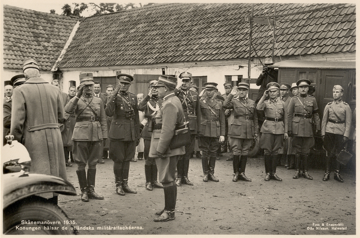 Skånemanövern 1935. 
Konungen hälsar de utländska militärattachéerna på en gårdsplan någonstans i Skåne.