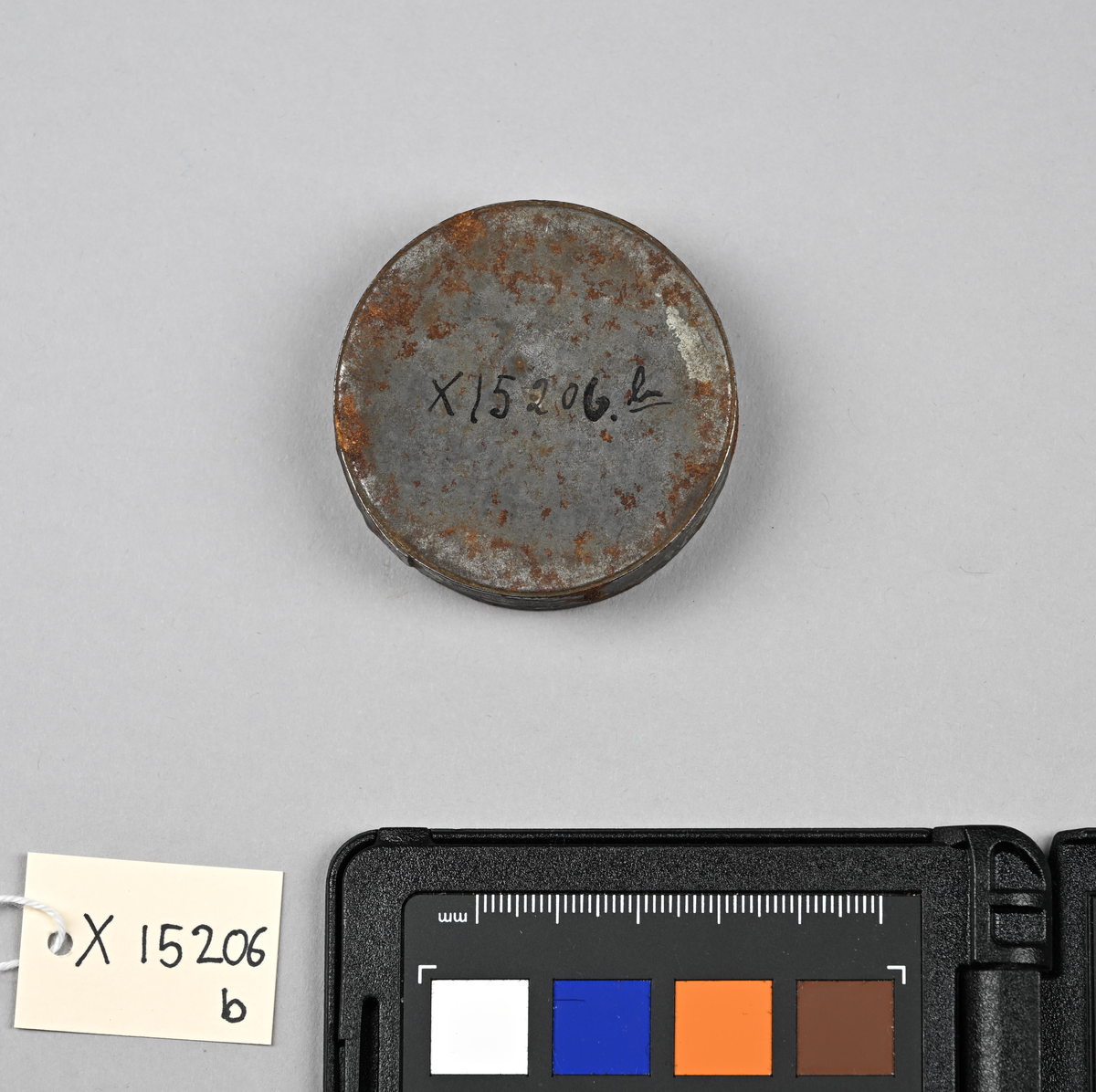 X 15206 b Fra protokoll: "Seglbokser, blikk. Alle av flat cylindrisk form med lokk, men av forskj. dimensjoner. Flere av boksene med hull for snor. En av dem har i behold en gammel snor av lær."