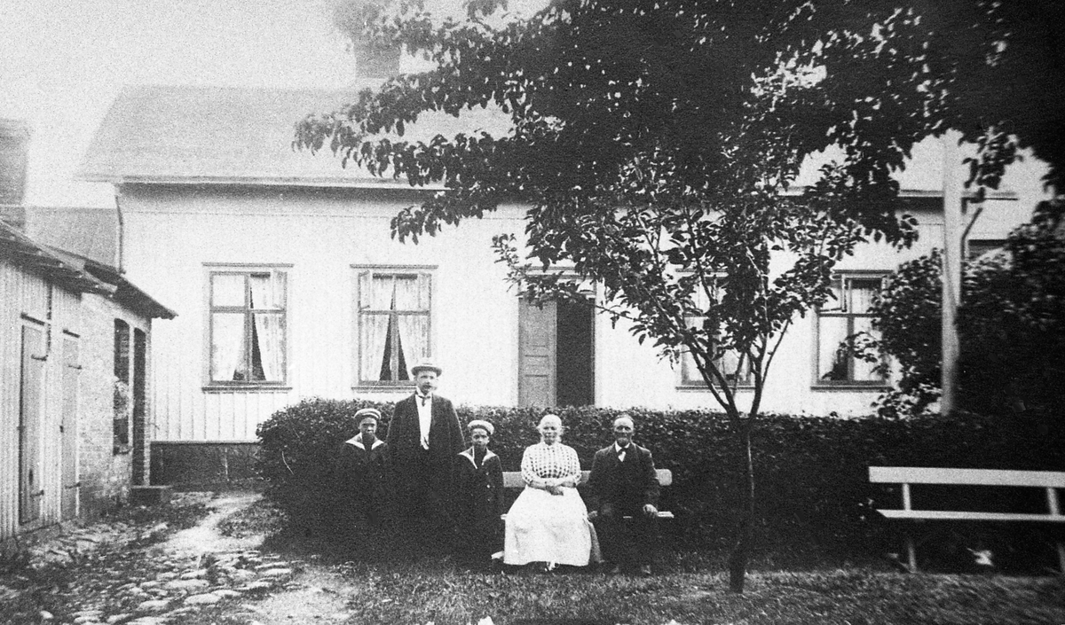 "Lelle-Johan" med familj på Slottsgatan 13, Lotsen 3 i Varberg. Johan Andersson sitter längst till höger med hustrun Dorothea, "Thea". Deras son Fredrik Andersson, typograf på Norsteds i Stockholm, är på besök omkring 1913 med sina två söner Åke (f. 1908-03-09) till höger och Erik (f. 1905-11-06) till vänster. Hustrun Gerda tar bilden. 

När Johan och Thea gifte sig 1878 noterades han som bärare, fd sjöman, och husägare i kvarter IV, men 1884 stod Johan som ägare till fastigheten på Platsarna. Han var fiskare men om somrarna körde han även badgäster till Getterön. Thea var från Polen och arbetade som baderska i badhuset. Johan försvann till sjöss utan att bli återfunnen, men Thea levde till 1923. Fastigheten kallades sedan "Thea-Eriks" och "Tamms", efter ägaren P G Tamm 1919-1924.