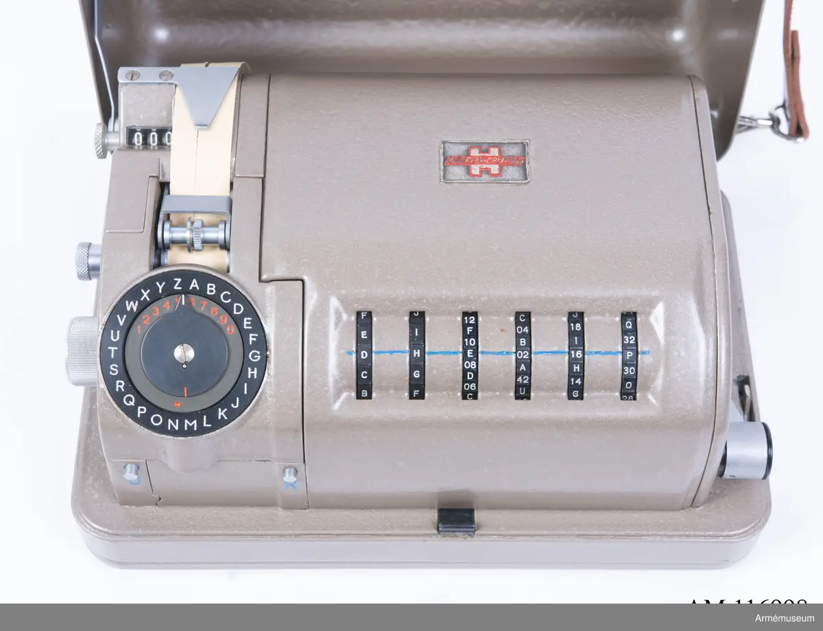 Med nycklar.

Text på liten bricka på högra sidan: "Type CX-52 No 10924, Manufactured for Crypto AG Zug Switzerland by AB Cryptoteknik Stockholm Sweden".

Under krypteringsapparatens lock finns en liten vit lapp märkt "MV Boden Avd 4 Översyn 11 68", dvs troligen Miloverkstaden Boden, november 1968. 

De fysiska nycklarna ger olika access till användarna. Den nyckel med ett hack i ovansidan på nyckeln öppnar endast yttre luckan och dras sedan ut. Därpå förs nyckeln med två hack på nyckelörat in vilket gör att inre luckan går att öppna. Den senare nyckeln ger access till själva innandömet och rotorhjulen går att ta ut efter att sprinten på högra sidan dragits ut.