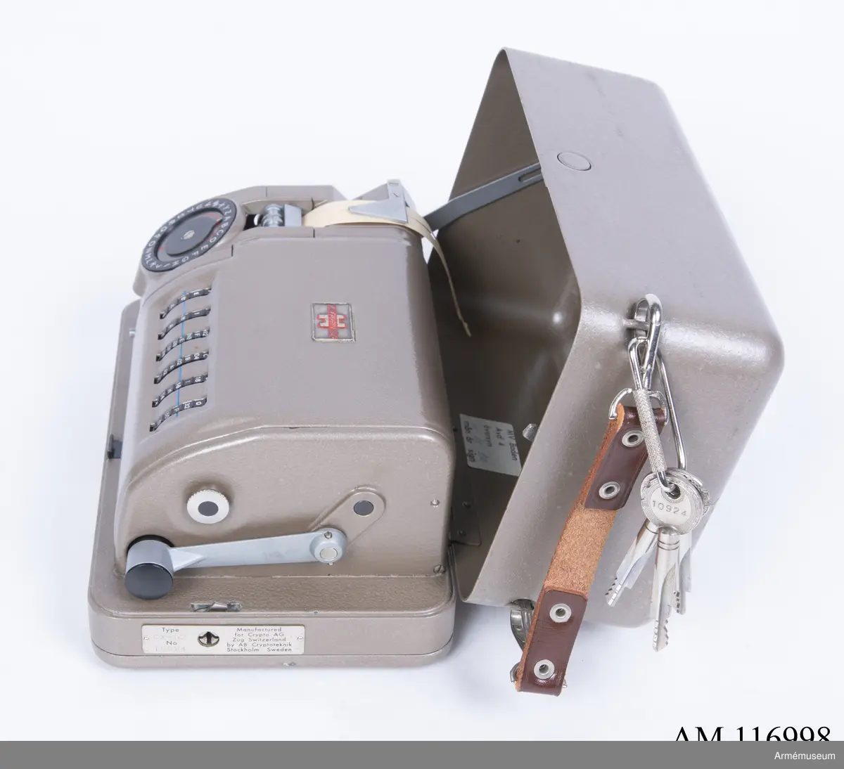Med nycklar.

Text på liten bricka på högra sidan: "Type CX-52 No 10924, Manufactured for Crypto AG Zug Switzerland by AB Cryptoteknik Stockholm Sweden".

Under krypteringsapparatens lock finns en liten vit lapp märkt "MV Boden Avd 4 Översyn 11 68", dvs troligen Miloverkstaden Boden, november 1968. 

De fysiska nycklarna ger olika access till användarna. Den nyckel med ett hack i ovansidan på nyckeln öppnar endast yttre luckan och dras sedan ut. Därpå förs nyckeln med två hack på nyckelörat in vilket gör att inre luckan går att öppna. Den senare nyckeln ger access till själva innandömet och rotorhjulen går att ta ut efter att sprinten på högra sidan dragits ut.