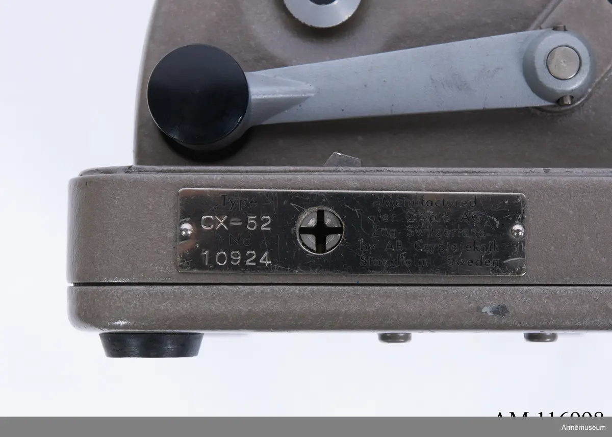 Med nycklar.

Text på liten bricka på högra sidan: "Type CX-52 No 10924, Manufactured for Crypto AG Zug Switzerland by AB Cryptoteknik Stockholm Sweden".

Under krypteringsapparatens lock finns en liten vit lapp märkt "MV Boden Avd 4 Översyn 11 68", dvs troligen Miloverkstaden Boden, november 1968. 

De fysiska nycklarna ger olika access till användarna. Den nyckel med ett hack i ovansidan på nyckeln öppnar endast yttre luckan och dras sedan ut. Därpå förs nyckeln med två hack på nyckelörat in vilket gör att inre luckan går att öppna. Den senare nyckeln ger access till själva innandömet och rotorhjulen går att ta ut efter att sprinten på högra sidan dragits ut.