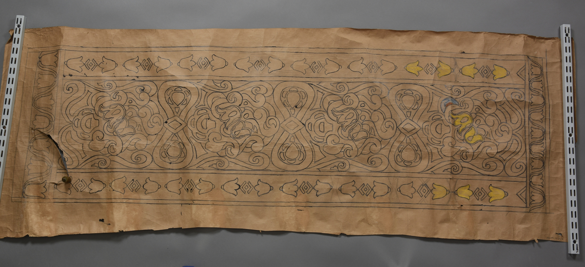 Stilisert motiv, blomar, klokkeforma blomar som bord på langsidane og kortsidane, men to litt ulike utforminger. Blomeornamentikk, diverse geometriske figurer som romber.