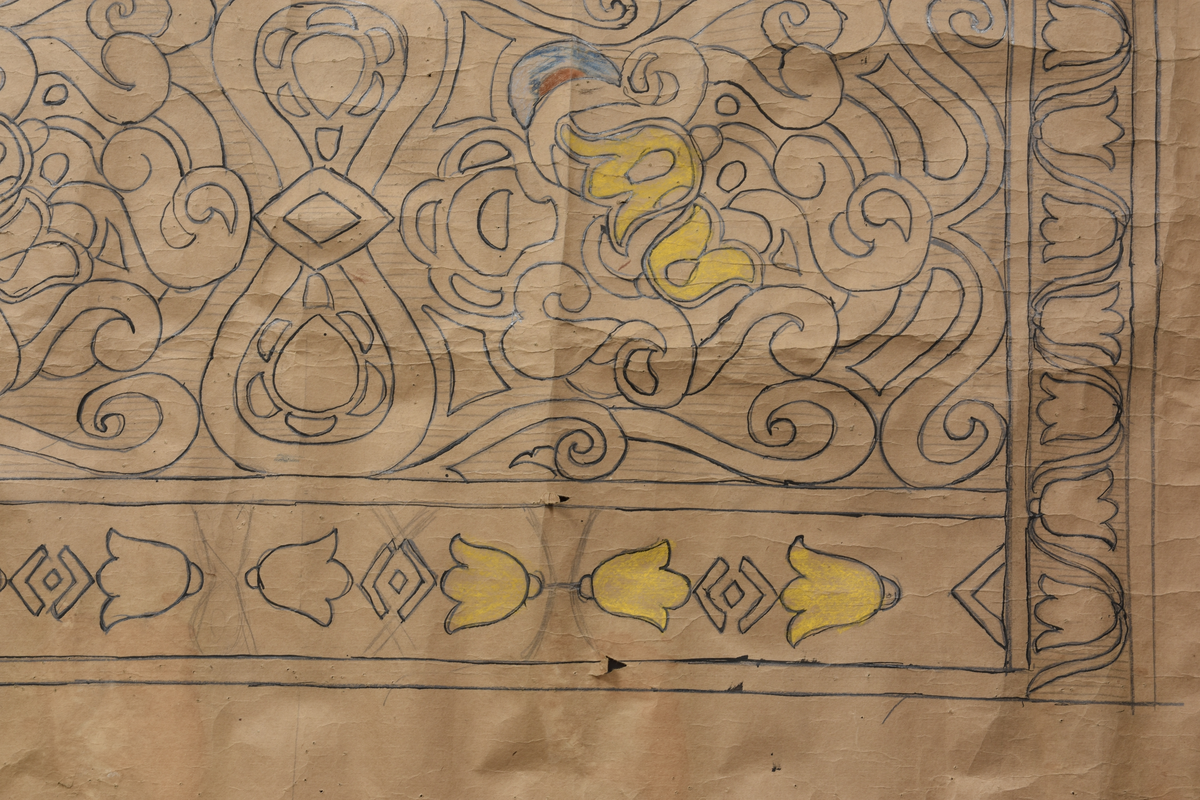 Stilisert motiv, blomar, klokkeforma blomar som bord på langsidane og kortsidane, men to litt ulike utforminger. Blomeornamentikk, diverse geometriske figurer som romber.