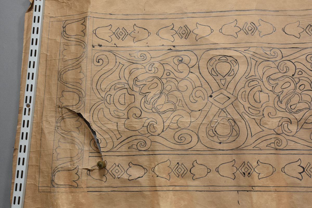 Stilisert motiv, blomar, klokkeforma blomar som bord på langsidane og kortsidane, men to litt ulike utforminger. Blomeornamentikk, diverse geometriske figurer som romber.