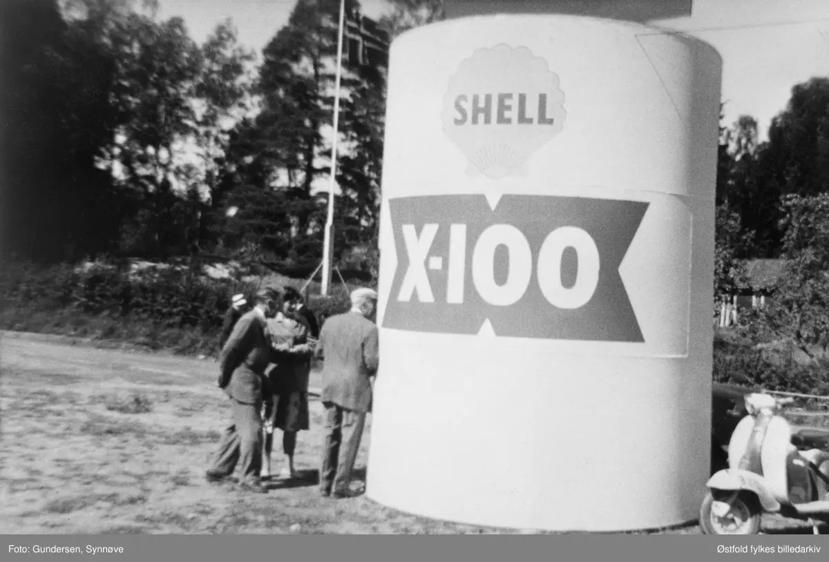 Fra Varteig kommunes 100-årsjubileum i 1961. Ved Varteig skole. Fra Bjarne Berbys utstilling av en oljeboks som han hadde lagd selv. B. Berby har bilverksted og bensinstasjon på Ise. Oljeboksen reklamerer for SHELL X.100.