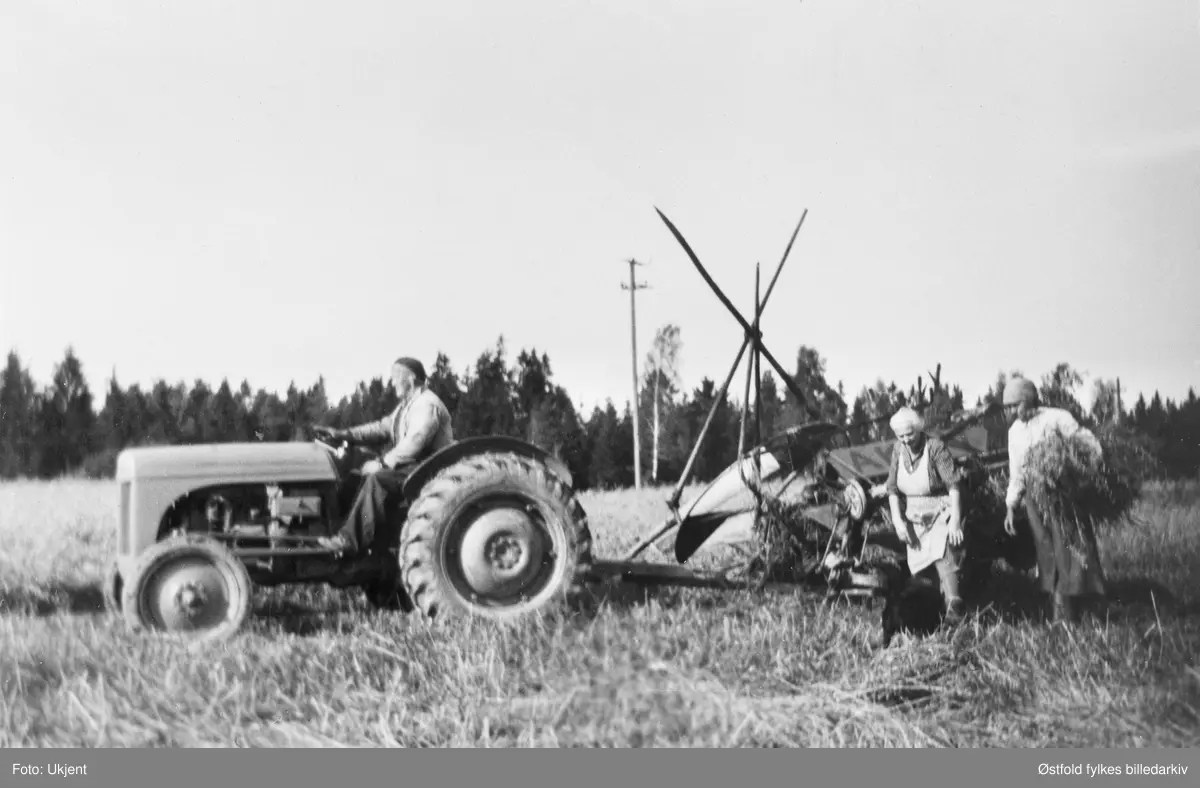 Skuronn på Strømnes i Varteig ca. 1950-55. Bjarne Lilleng  på traktoren, merke Ferguson. Ved selvbinderen Linna og Elise Strømnes. På gården Strømnes.