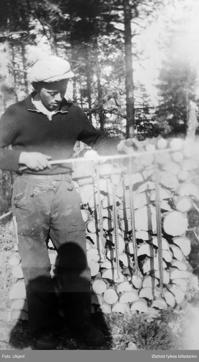 "Skogsarbeid kan være så mangt!" Ole Kullerud  fra Varteig, med en fangst på fire huggormer!! Bildet er tatt på Kullerudmosen i 1944.