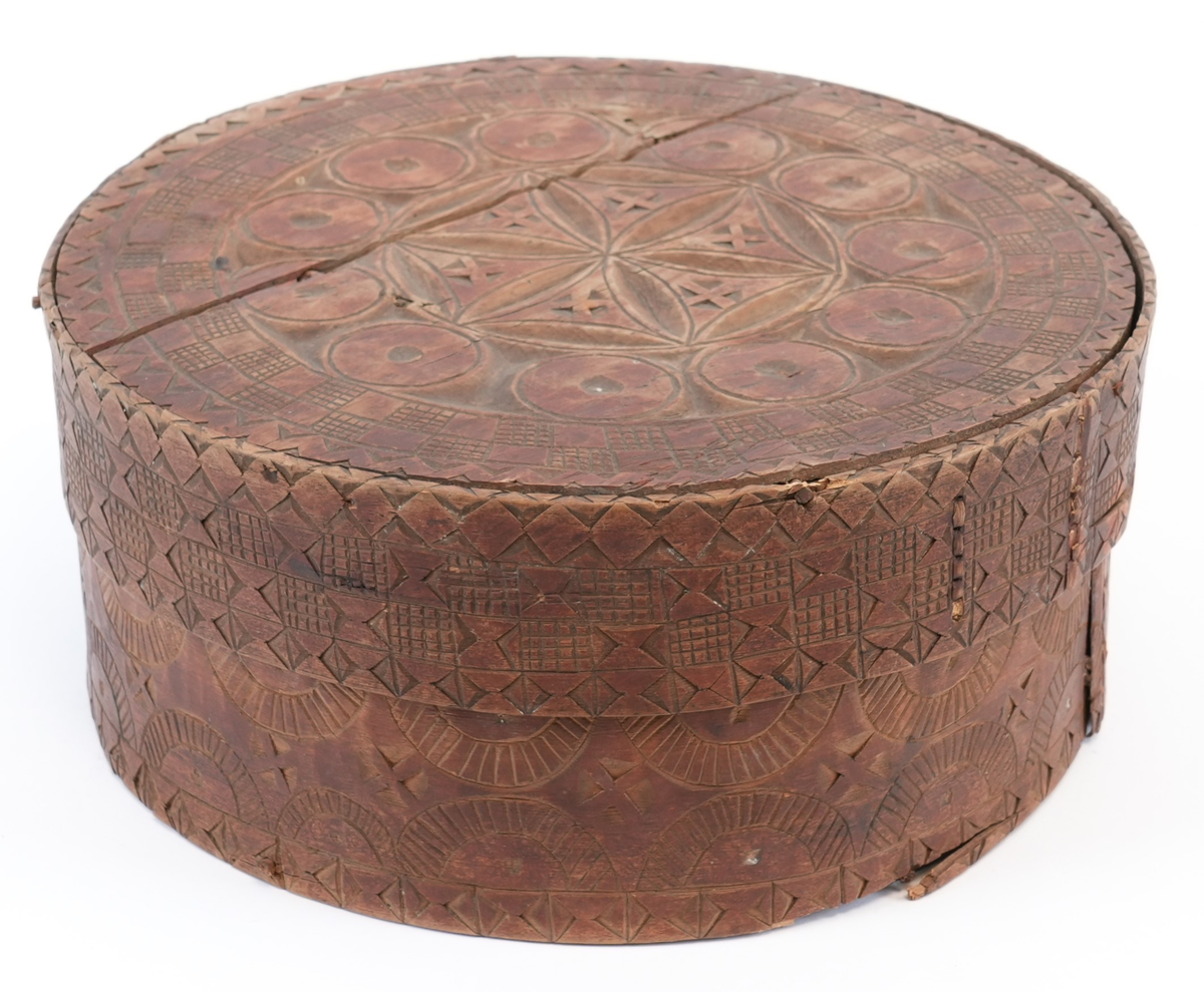 Karveskurd over heile øskja. På toppen av lokket ei sentral seksbladrose innskriven i ein sekskant med konkave sider, alt i ein sirkel. Mellom roseblader utskorne krysskors. Rundt rosa ei brei stripe med utskorne sirklar. Rundt dei, eit maskulint muruspjeld og sikksakk langs kanten. På sideveggen av lokket dobbel sikksakk langs kanten og muruspjeld med vekslende felt (rutenett og ståande timeglass symbol). På sideveggen av behaldaren, langs kantane stripar med ståande timeglass symbol. Mellom dei halvsirklar og krysskors.