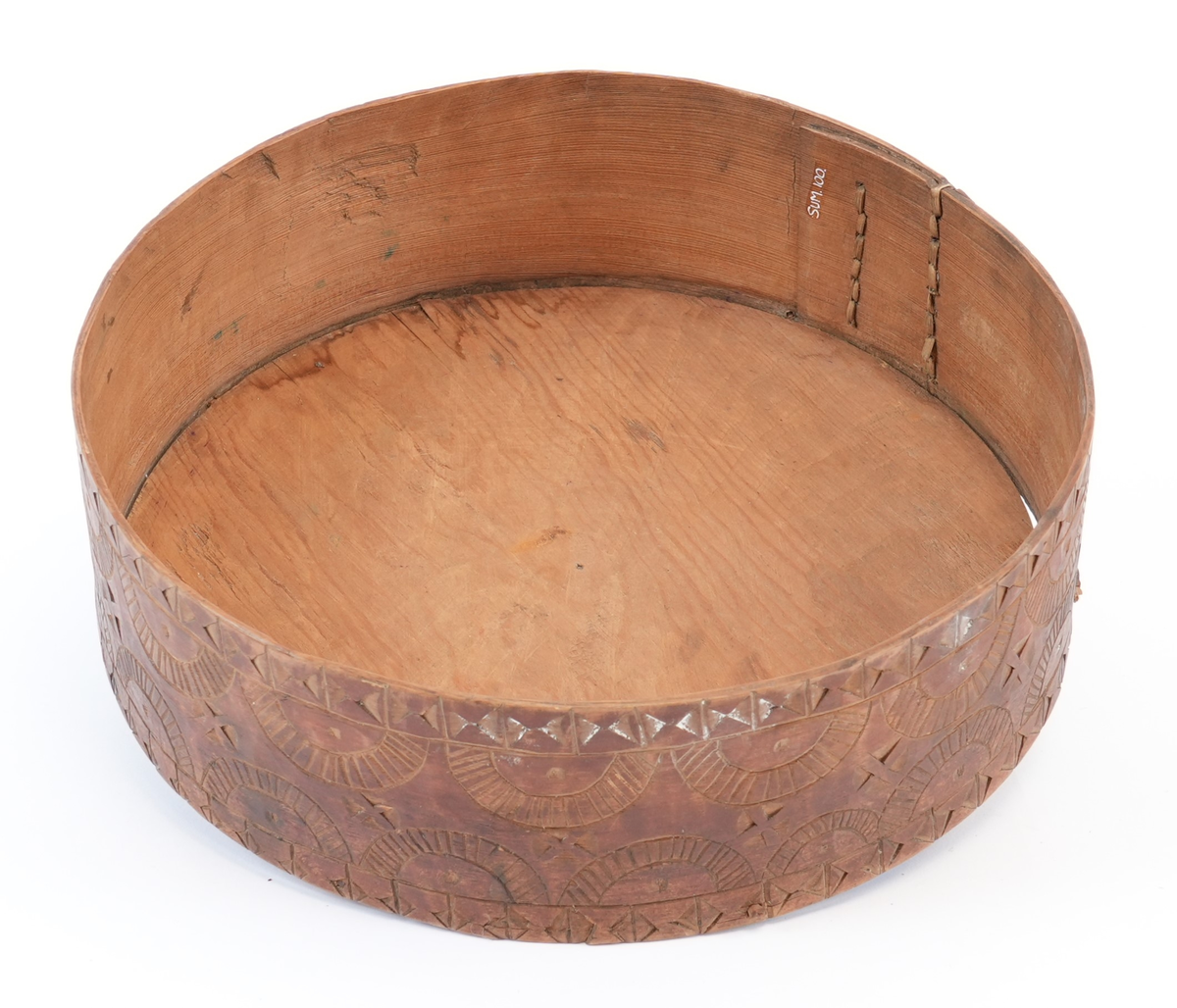 Karveskurd over heile øskja. På toppen av lokket ei sentral seksbladrose innskriven i ein sekskant med konkave sider, alt i ein sirkel. Mellom roseblader utskorne krysskors. Rundt rosa ei brei stripe med utskorne sirklar. Rundt dei, eit maskulint muruspjeld og sikksakk langs kanten. På sideveggen av lokket dobbel sikksakk langs kanten og muruspjeld med vekslende felt (rutenett og ståande timeglass symbol). På sideveggen av behaldaren, langs kantane stripar med ståande timeglass symbol. Mellom dei halvsirklar og krysskors.