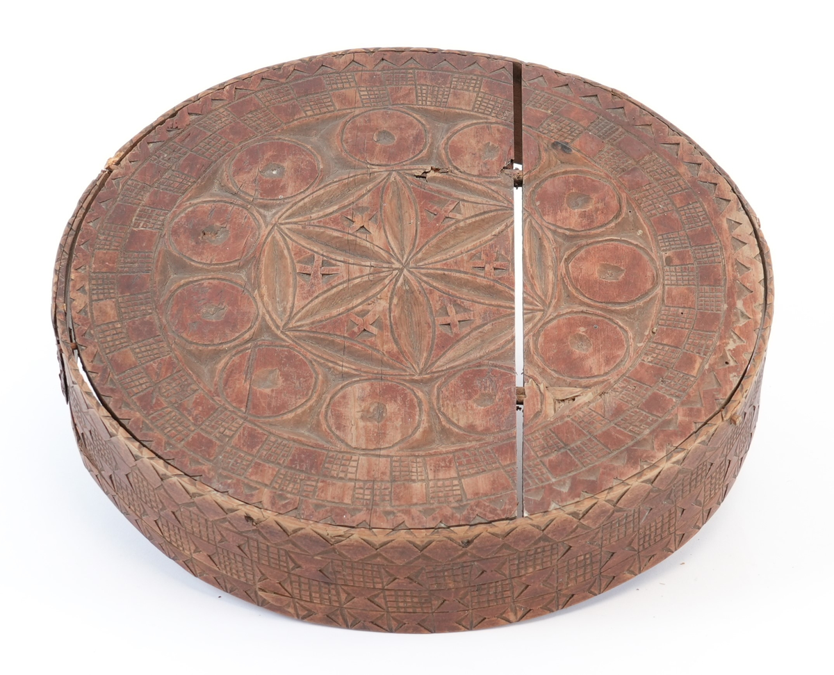 Karveskurd over heile øskja. På toppen av lokket ei sentral seksbladrose innskriven i ein sekskant med konkave sider, alt i ein sirkel. Mellom roseblader utskorne krysskors. Rundt rosa ei brei stripe med utskorne sirklar. Rundt dei, eit maskulint muruspjeld og sikksakk langs kanten. På sideveggen av lokket dobbel sikksakk langs kanten og muruspjeld med vekslende felt (rutenett og ståande timeglass symbol). På sideveggen av behaldaren, langs kantane stripar med ståande timeglass symbol. Mellom dei halvsirklar og krysskors.