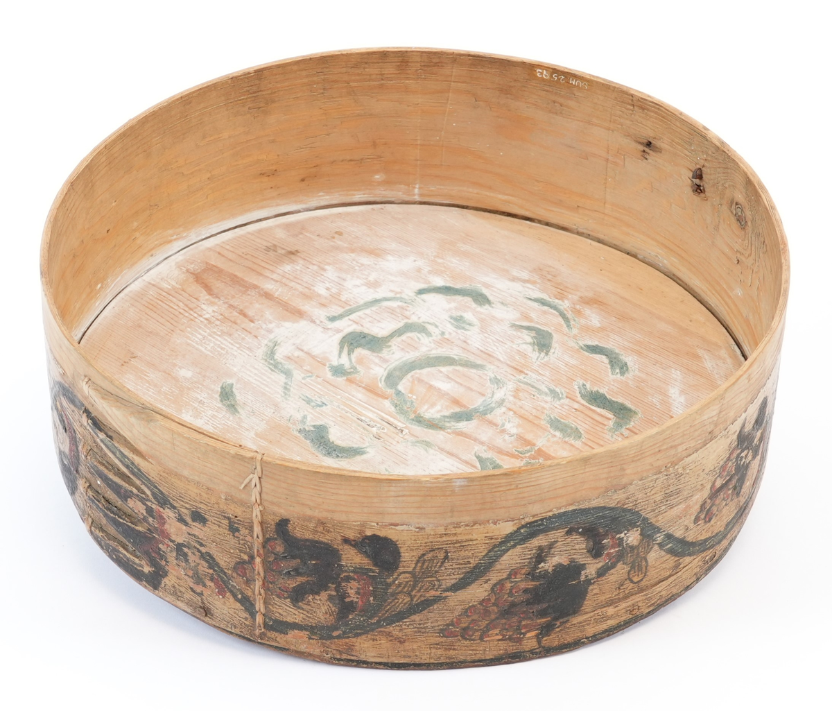 På toppen av lokket karveskurd: i midten utskore eit stort, sentralt buekors med rutenett og sikksakk inni; langs kanten utskoren sikksakk. Mellom dei, på mørkegrøn bakgrunn måla raude og gule blomstrar og slynger. På sideveggen, på kvit bakgrunn måla grøne rankar med raude og gule blomstrar og drueklasar. Innvendig restar av blå målingslaget: på lokket synleg blomsterform, på botnen s-ar.