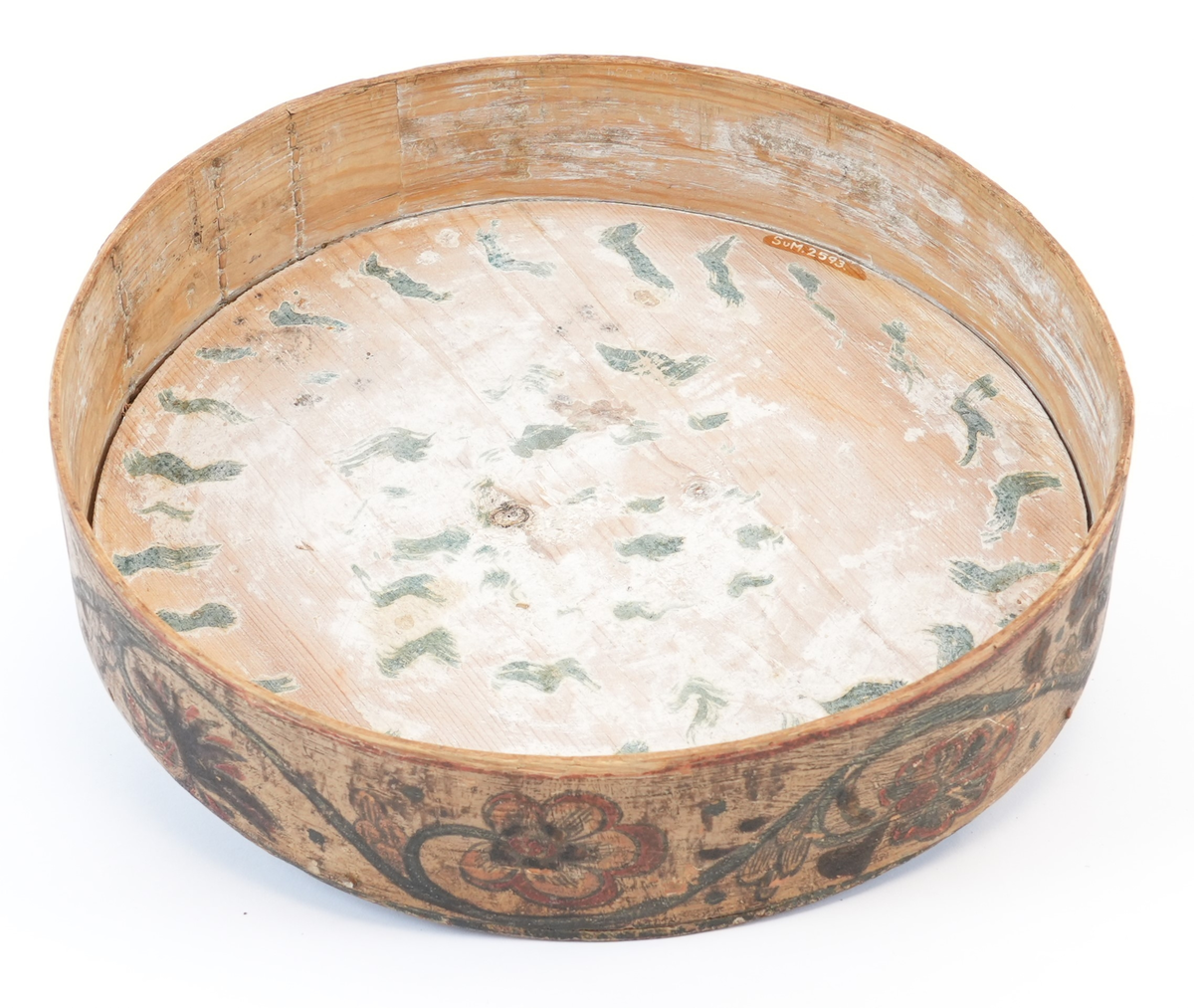 På toppen av lokket karveskurd: i midten utskore eit stort, sentralt buekors med rutenett og sikksakk inni; langs kanten utskoren sikksakk. Mellom dei, på mørkegrøn bakgrunn måla raude og gule blomstrar og slynger. På sideveggen, på kvit bakgrunn måla grøne rankar med raude og gule blomstrar og drueklasar. Innvendig restar av blå målingslaget: på lokket synleg blomsterform, på botnen s-ar.