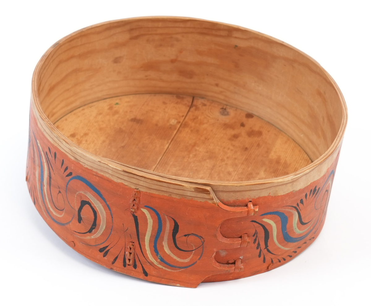 Viksdalsmåling. Utvendig, den heile øskja måla vermilion. På toppen av lokket ein stor, sentral seksbladblomster med blader som store s-ar, måla blå, svart og gul. Mellom dei blå og gule bladverk, langs kanten små blå s-ar. På sideveggen krøllete rankar i same fargar, med svarte bladverk i mellom.