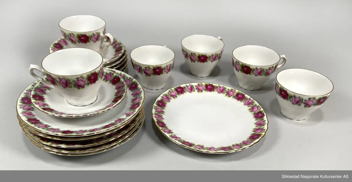 Kaffeservise for seks personer, kopp, tefat og asjett. Hvitt porselen dekorert med bord av trykte roser med bladverk (oldemors rose), langs munning av kopp og fat (oldemors rose). Forgylt langs munning, hank og kant på fat. Koppene har en bølgete form. Besstår av 18 deler.