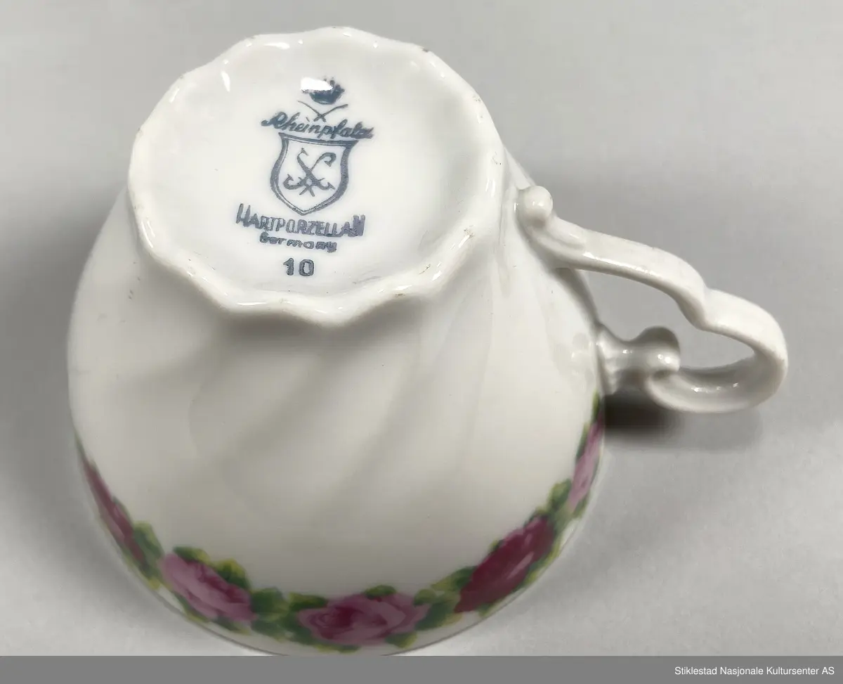 Kaffeservise for seks personer, kopp, tefat og asjett. Hvitt porselen dekorert med bord av trykte roser med bladverk (oldemors rose), langs munning av kopp og fat (oldemors rose). Forgylt langs munning, hank og kant på fat. Koppene har en bølgete form. Besstår av 18 deler.