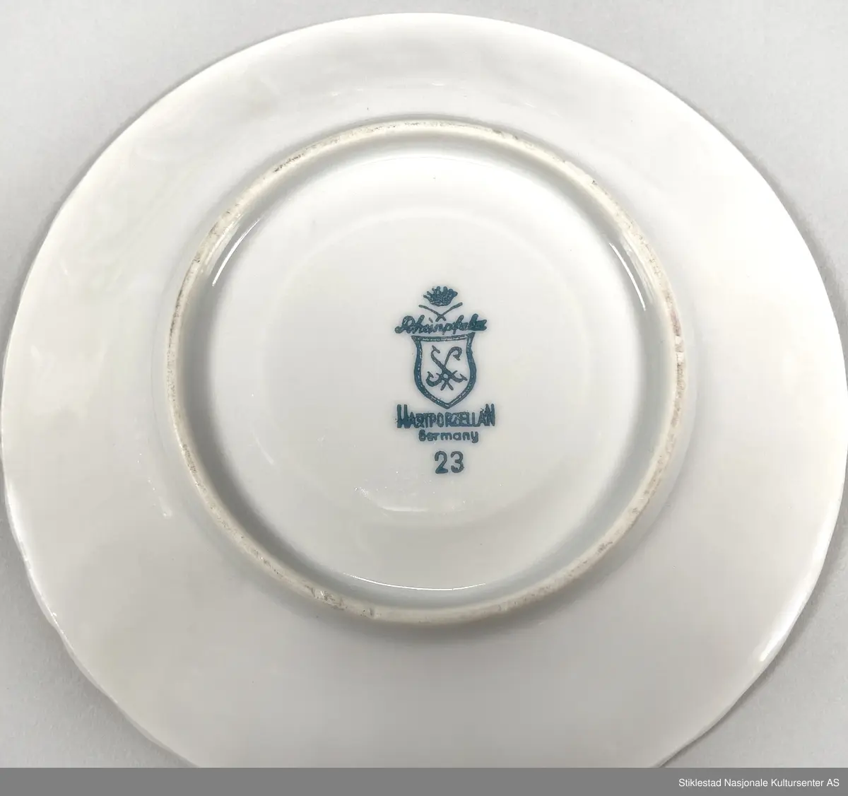 Kaffeservise for seks personer, kopp, tefat og asjett. Hvitt porselen dekorert med bord av trykte roser med bladverk (oldemors rose), langs munning av kopp og fat (oldemors rose). Forgylt langs munning, hank og kant på fat. Koppene har en bølgete form. Besstår av 18 deler.