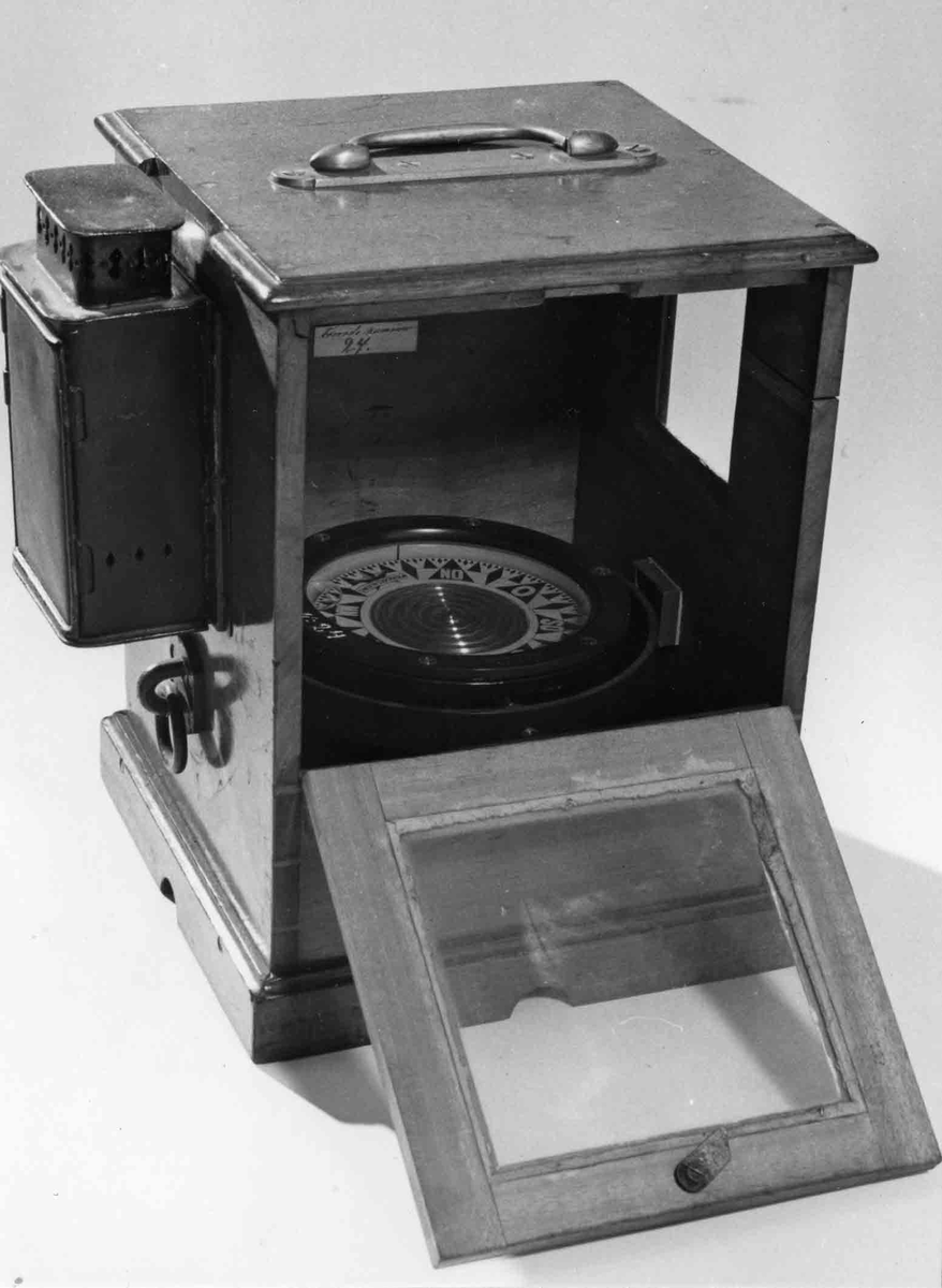 Båtkompass med nakterhus av mahogny. Kompass, sprit, märkt: "G.W. Lyth, Stockholm 7381", samt med vit färg "N. 24" (förrådsnummer). 
Ros streckindelad, märkt: "Patent Lemcke. G.W. Lyth. Stockholm". Nakterhus, fyrkantigt, med dörr. Fäste för 2 lanternor.
Märkt med vit färg "24".