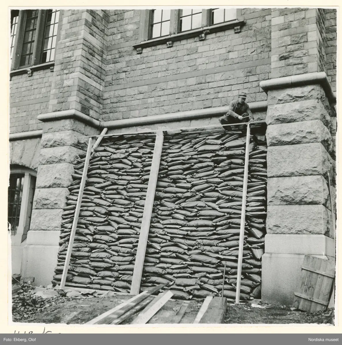 Bild tagen vid Nordiska museets åtgärder inom projektet För luftskyddet under beredskapstiden 1939 till 1940. Byggnaden skyddas med sandsäckar som staplas mot fasaden.