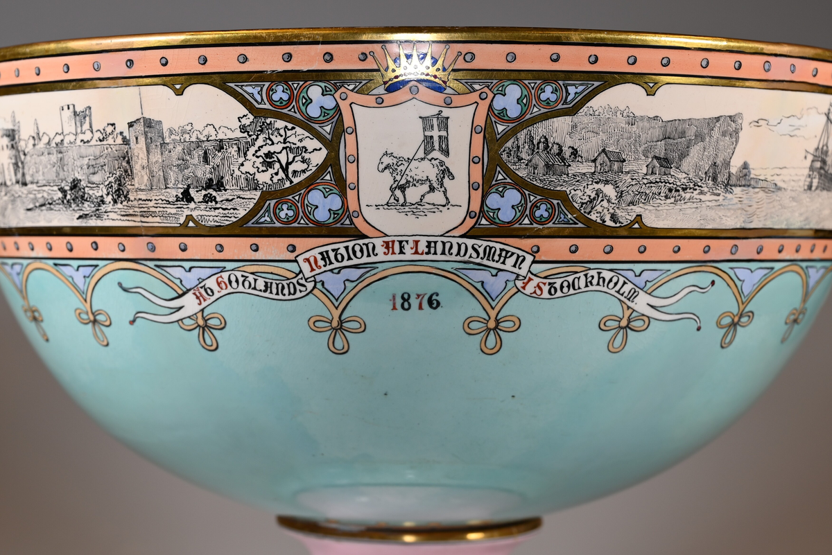 Motiv runt skålens mynning, fr.v: 1. Gotlands landskapsvapen, krönt, med inskription: "AT GOTLANDS NATION AF LANDSMAN I STOCKHOLM 1876". 2. Marinmotiv med tre fartyg, koggar. 3. S:t Nicolai kyrkoruin. 4. Pärkspel. 5. Stenkors, ringkors. 6. Visbysilhuett mot havet med ringmuren.
