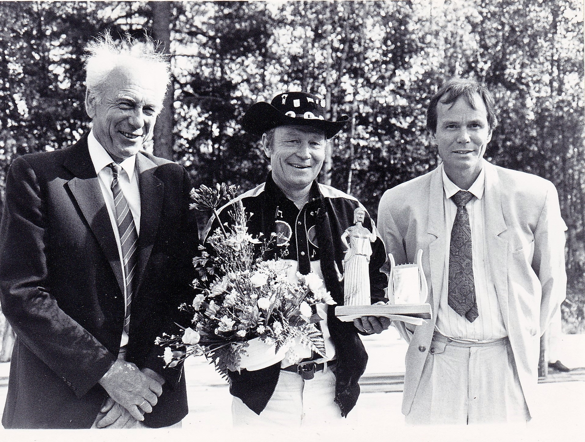 Gruppeportrett av Knut T. Storbukås "Sputnik", med to menn fotografert ved mottakelse av kulturpris i 1992.