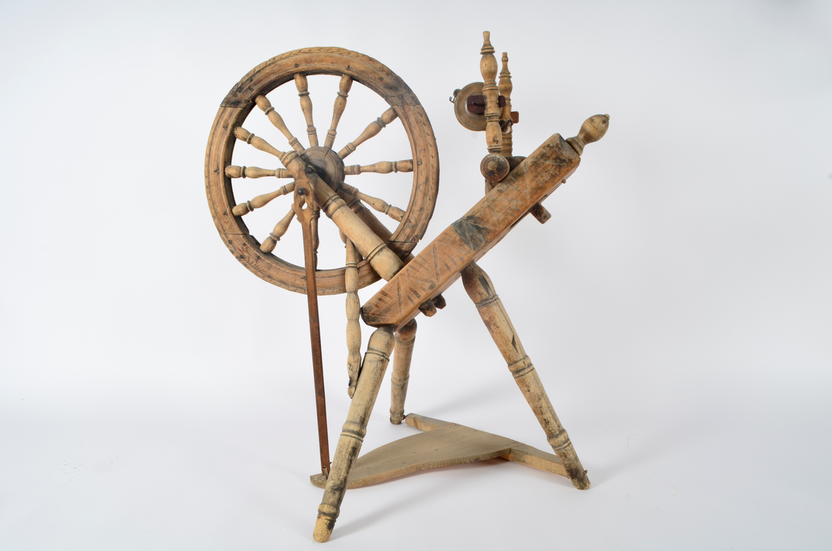Hjul, skråbrett og trøbrett av gran, resten av bjørk. Umalt. Gjennom skråbrettet går spinnartyet som består av to sterkt profilerte dokker, snelle med snellevenger og seks jernkroker på hver. Spinnartyet er  pinnet fast i stilleskrue med hode i enden av skråbrettet. På foten har spinnartyet enkle utskjæringer. Selve rokkehjulet er naglet sammen av fem deler. Tolv sterkt profilerte eiker er tappet inn i hjulet. Akslingen av jern, festet til en trepinne på hver side av hjulet. Disse er igjen tappet gjennom skråbrettet. På den ene siden er akslingen forlenget og festet til trøastikka. Denne er bundet til trøbrett med tau. Tre føtter på skrå.Disse er noe profilerte. Trøbrettet festet mellom to av beina. Øverst på skråbrettet hull til feste for strytein til linspinning. Utskåret dekor på sidene av skråbrettet. Under er innskåret initialer og årstall. 
Trøbrett og trøastikk antagelig av nyere dato.