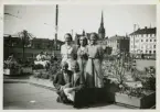 Erna Luther (överst till höger) var stewardess på Estonia. På fotografiet står Erna tillsammans med sina arbetskamrater invid odlingslådor i Gamla stan, Stockholm 1939 (möjligen 1938).