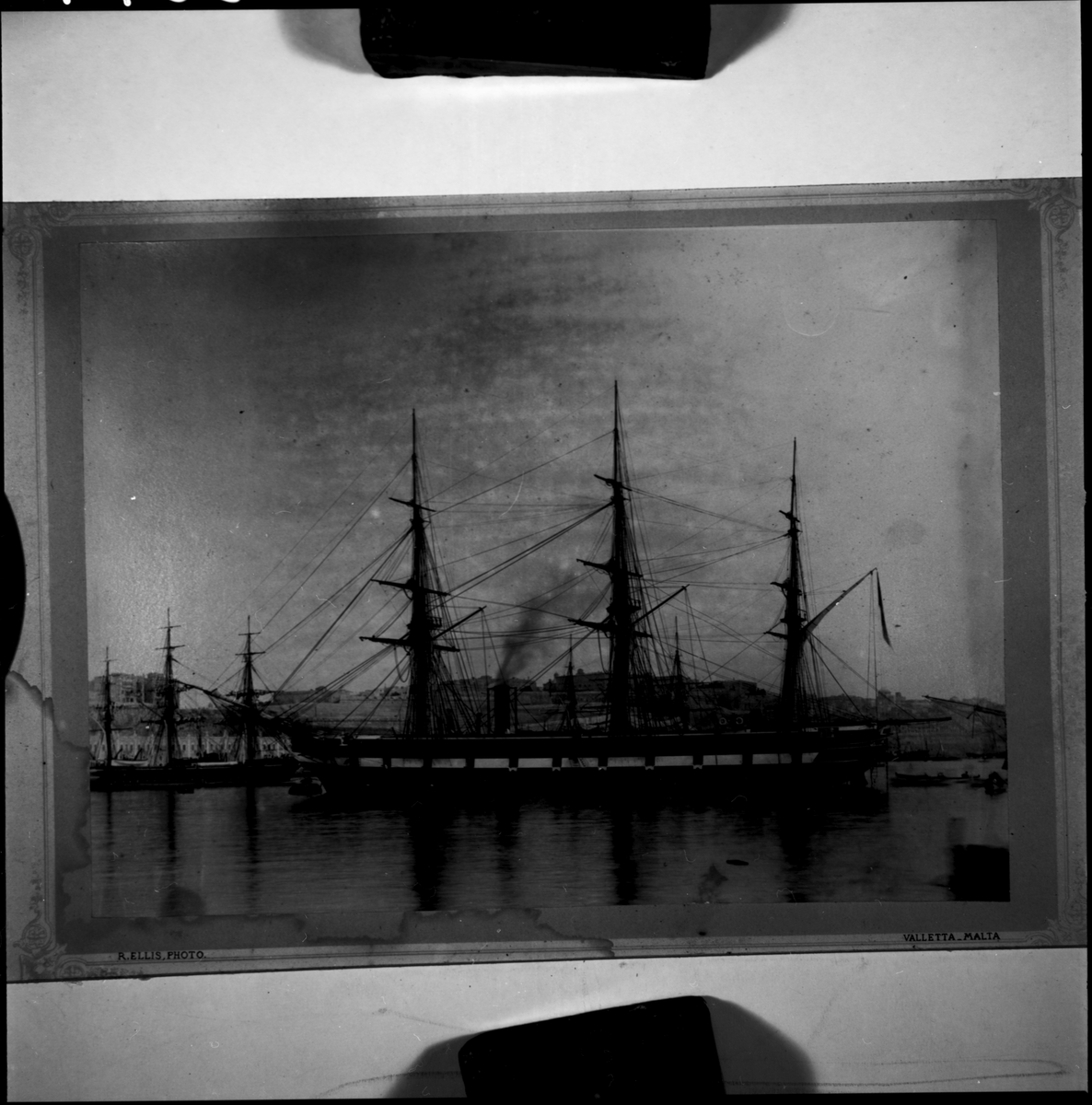 Bilden visar ångfregatten Vanadis från styrbordssida. Skeppet ankra vid en boj i Vallettas hamn på Malta under sin långresa 1883-1885. Alla segel är bärgade, styckportarna är öppna och kanonerna utförda. Ur skorstenen stiger rök. En grupp sjömän står på akterdäcket. Från akterskeppet hänger en repstege ner till vattenytan och flera små båtar verka trafikera från och till fregatten.
I bakgrunden syns Valettas stadsbefästningar och regeringspalatset Auberge de Castille et Léon.