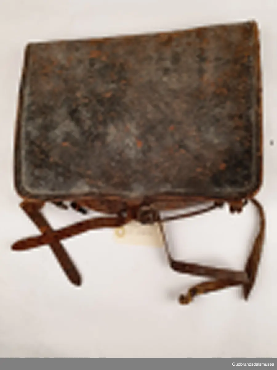 Liten ransel i skinn. Lokk med lukning og skulderreimer for å bære på ryggen.
Er foret med striestoff

Bredde 34cm
Høyde 28 cm
Dybde 8 cm

Teknikk; søm
Matriale ; lær/skinn