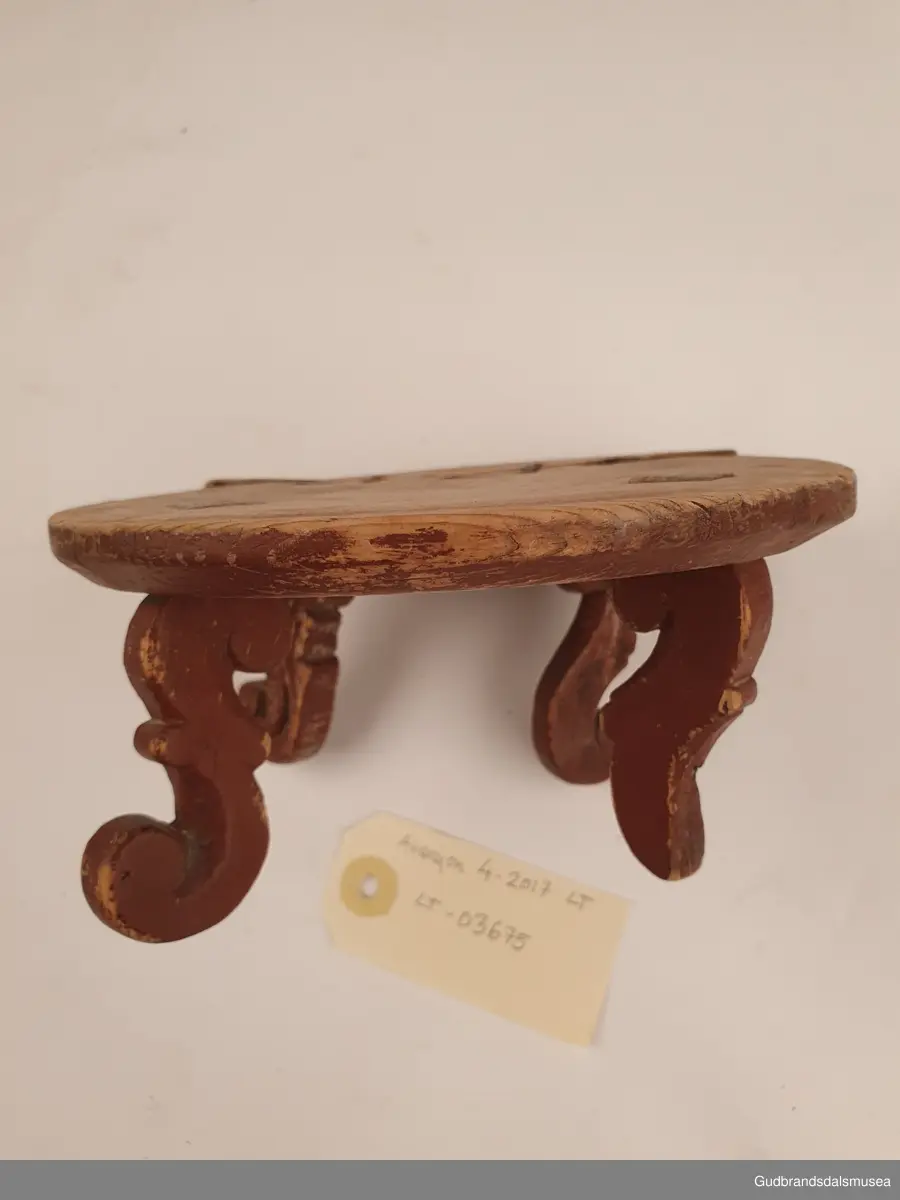 Smørbrikke i tre med 4 føtter. Føttene er ulikt utformet. En reprasjon på platen med kramper.
Merket med svimerke under FNV

Diameter 17 cm
Høyde 8 cm

Matriale; tre
Teknikk; utskjøring, sage, spikke, pusse, dreie